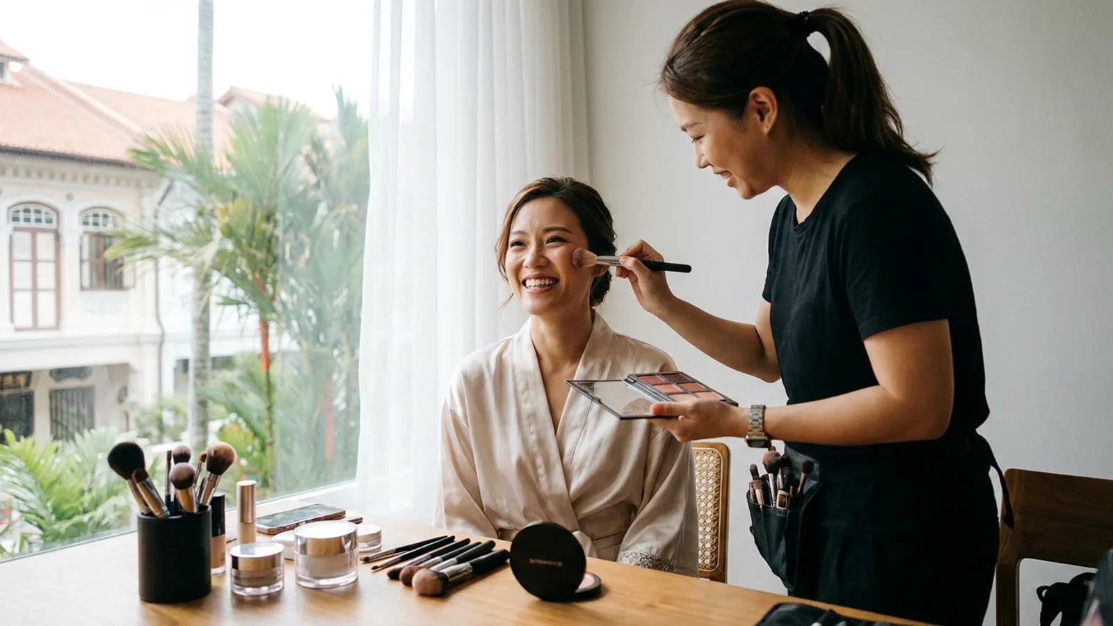A bridal makeup artist applying makeup to a bride on her wedding day in Singapore with soft natural light