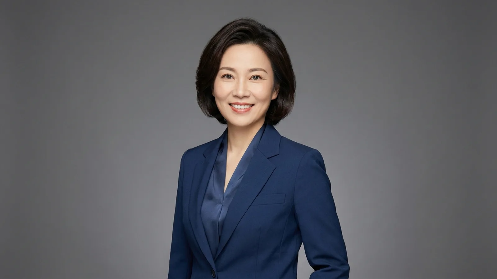 A professional posing for a clean corporate headshot against a neutral background in a Singapore studio