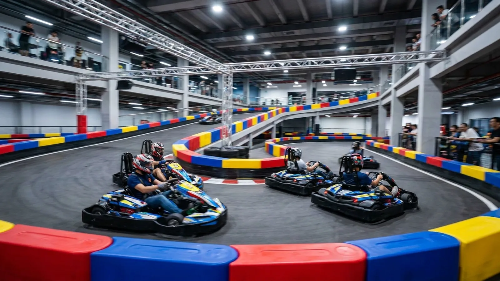 Electric go-karts racing on an indoor karting circuit in Singapore with motion blur, helmets and colourful track barriers