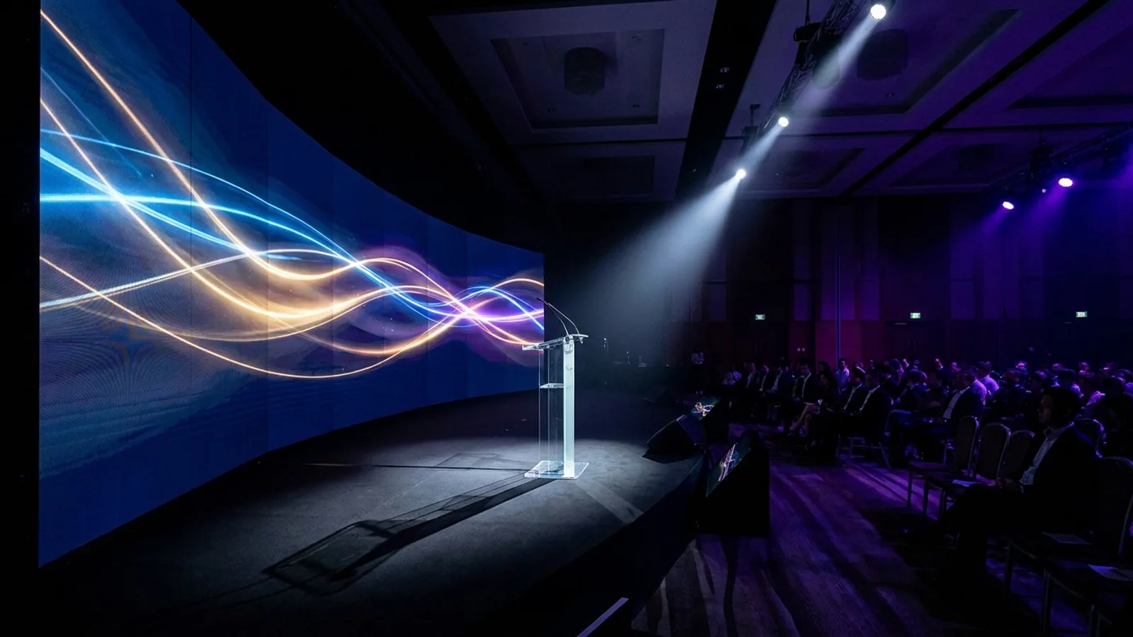 A large LED video wall backdrop behind a stage at a Singapore corporate event, displaying bright branded visuals