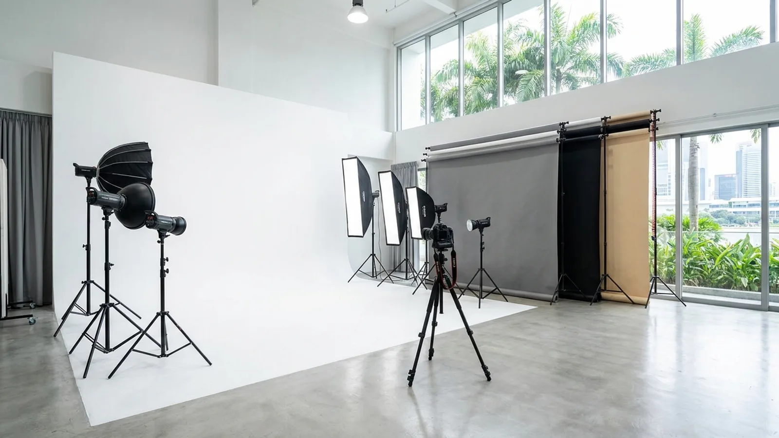 A rented photo studio space in Singapore with a white cyclorama wall, professional lighting, backdrops and a camera on a tripod