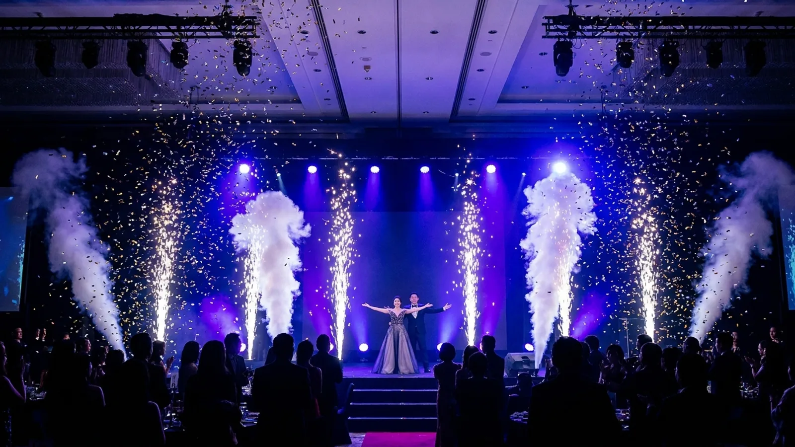 A stage at a Singapore event lit with cold sparkler fountains, CO2 jets and confetti during a key moment