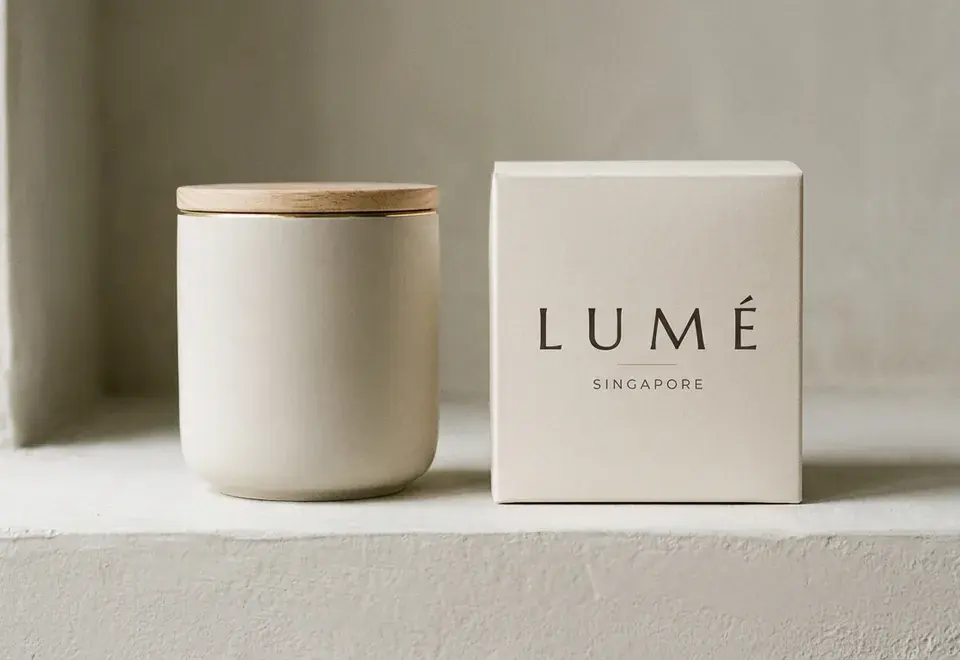 Bone Lumé carton beside a matte ceramic jar in soft daylight