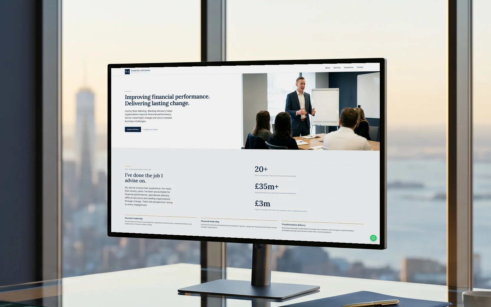 Wareing Advisory homepage, "Improving financial performance. Delivering lasting change." in navy serif beside a photo of Ross Wareing presenting to a boardroom, on a 27-inch monitor on a glass desk in a high-floor office at sunrise, the skyline and bay soft through the window