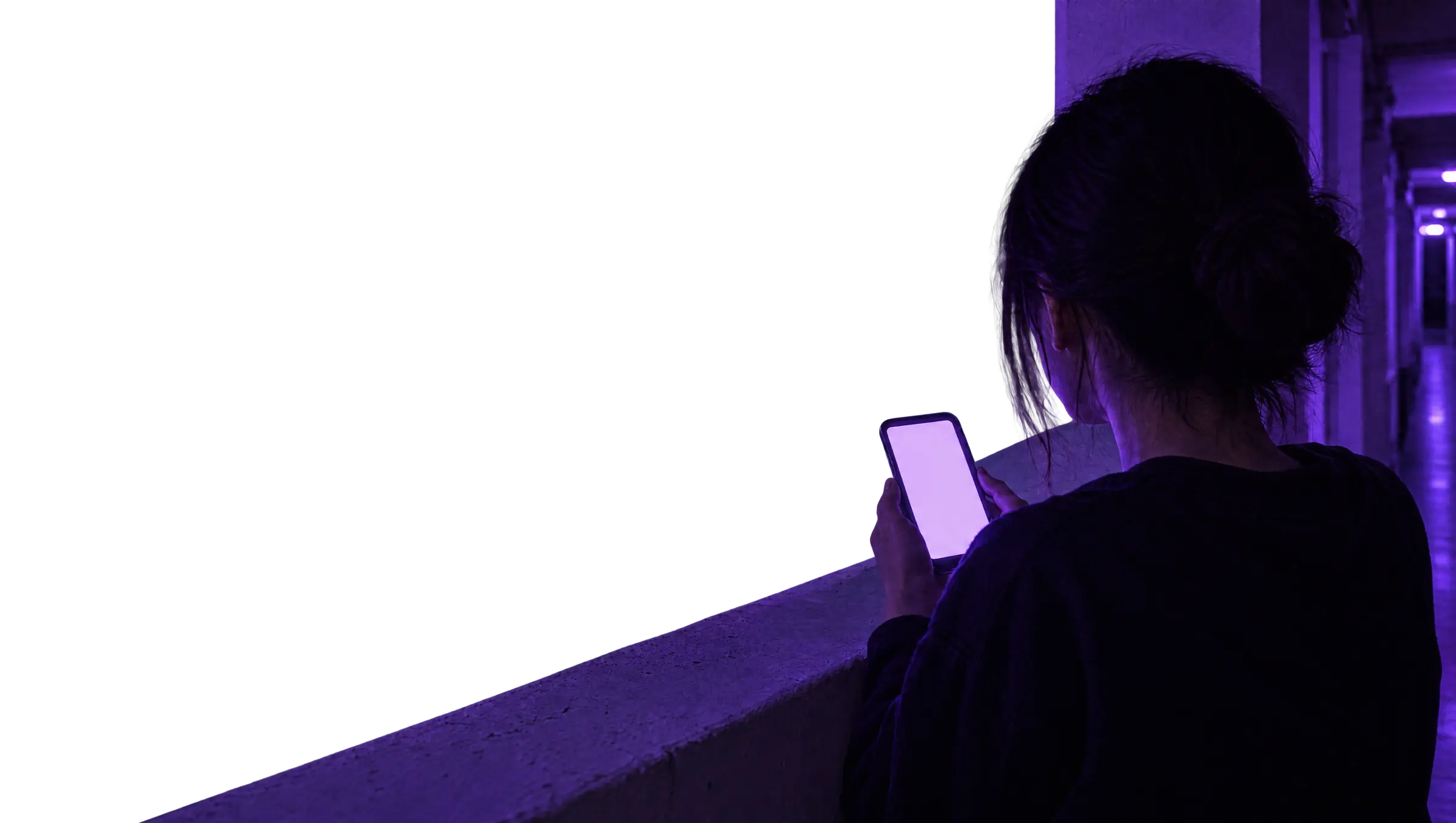 A woman on a high-floor HDB corridor at night, looking at her phone, the Singapore skyline lit purple behind her